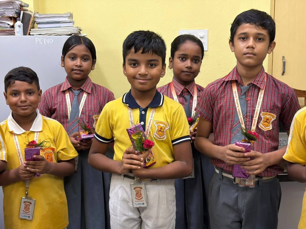 Students holding flowers and awards at a school ceremony